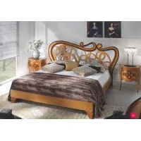 Picture A chic bedroom bed with a carved headboard