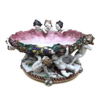 Zdjęcie Stroik uformowany w owalny kielich z bogato zdobionym brzegiem owocowym girlandami, wsparty na siedmiu aniołkach