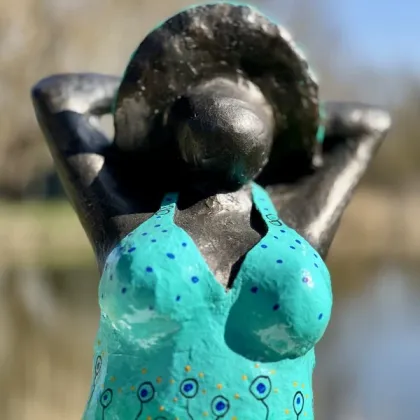 Zdjęcie Fantastyczna rzeźba przedstawiająca kobietę na kolanach w niebieskim kostiumie kąpielowym - doskonała ozdoba do ogrodu