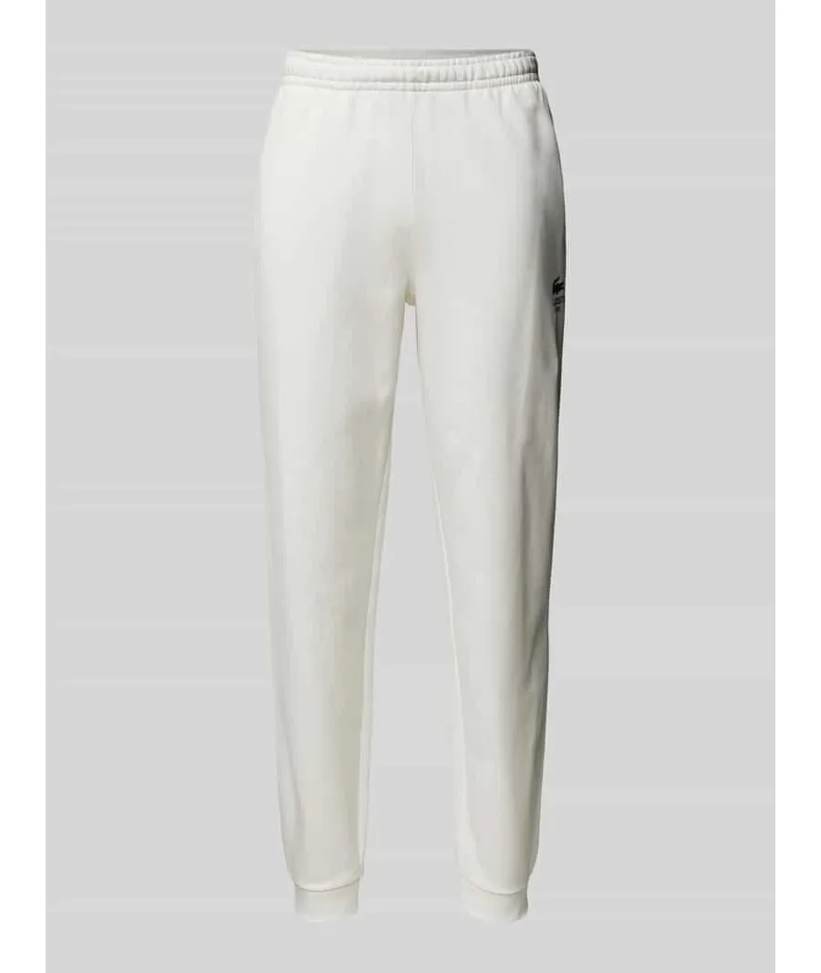 obrazek 1 Spodnie dresowe o kroju tapered fit z nadrukiem z logo model ‘HERITAGE’