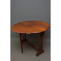 Picture Victorian mahogany drop leaf table having a shaped top with molded edge